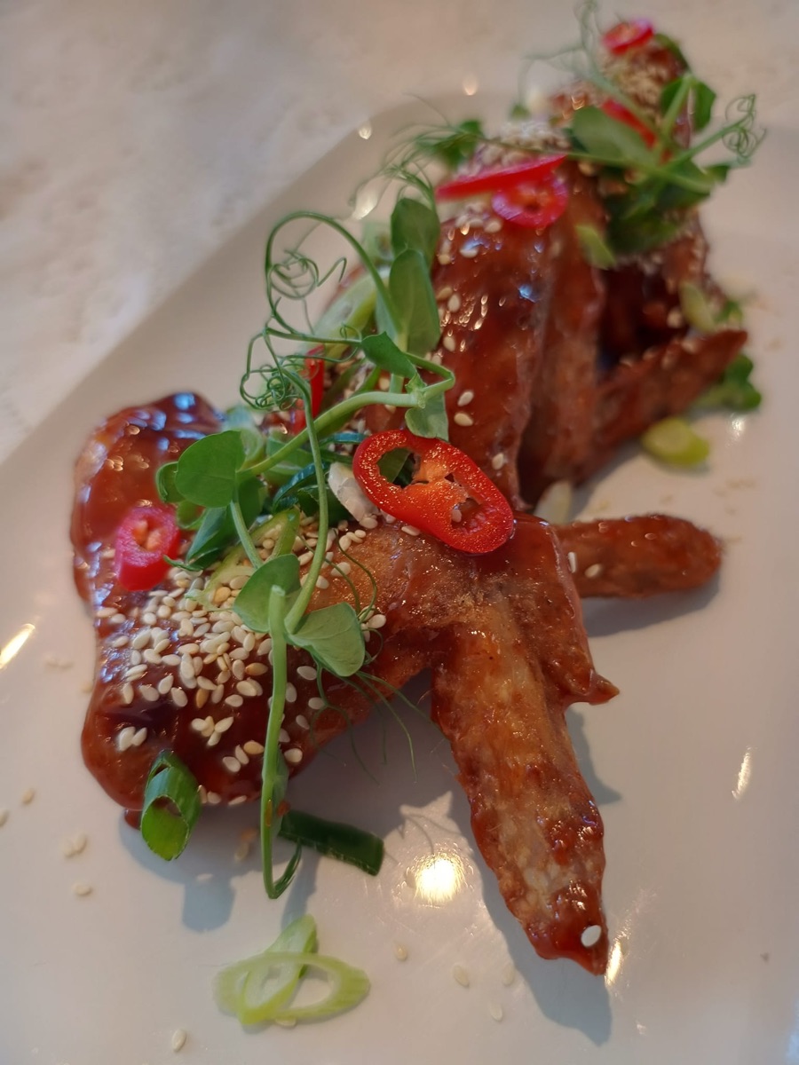 Sticky BBQ chicken wings with sesame seeds and spring onions
